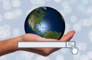 Man holding globe in hand with search field in front